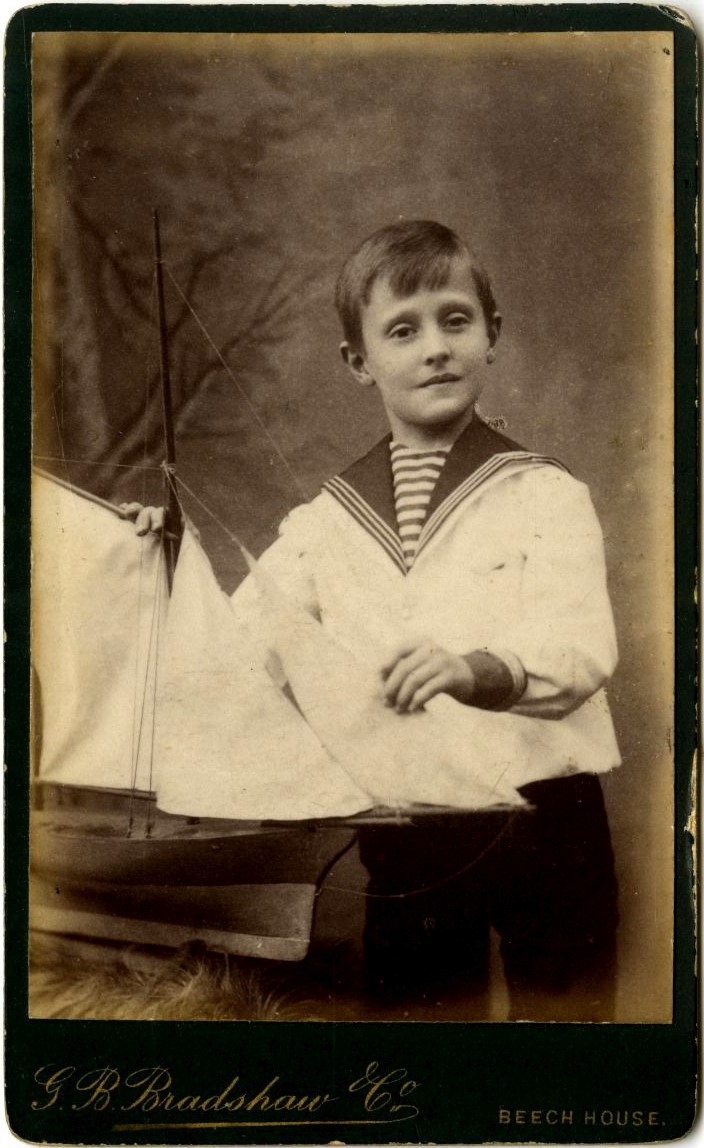 Boy in sailor suit. Toy yacht.
